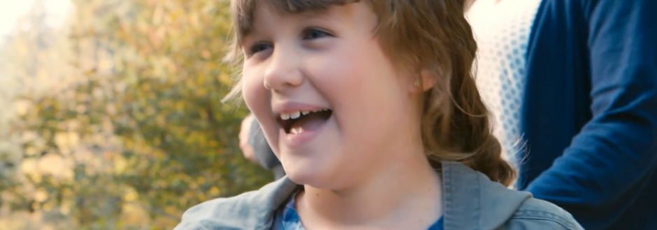 Macey smiles outside in front of her mom.