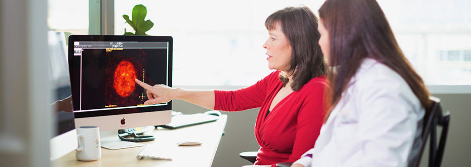 OHSU’s Dr. Amie Hiller and Dr. Delaram Safarpour review brain images in an office on a computer